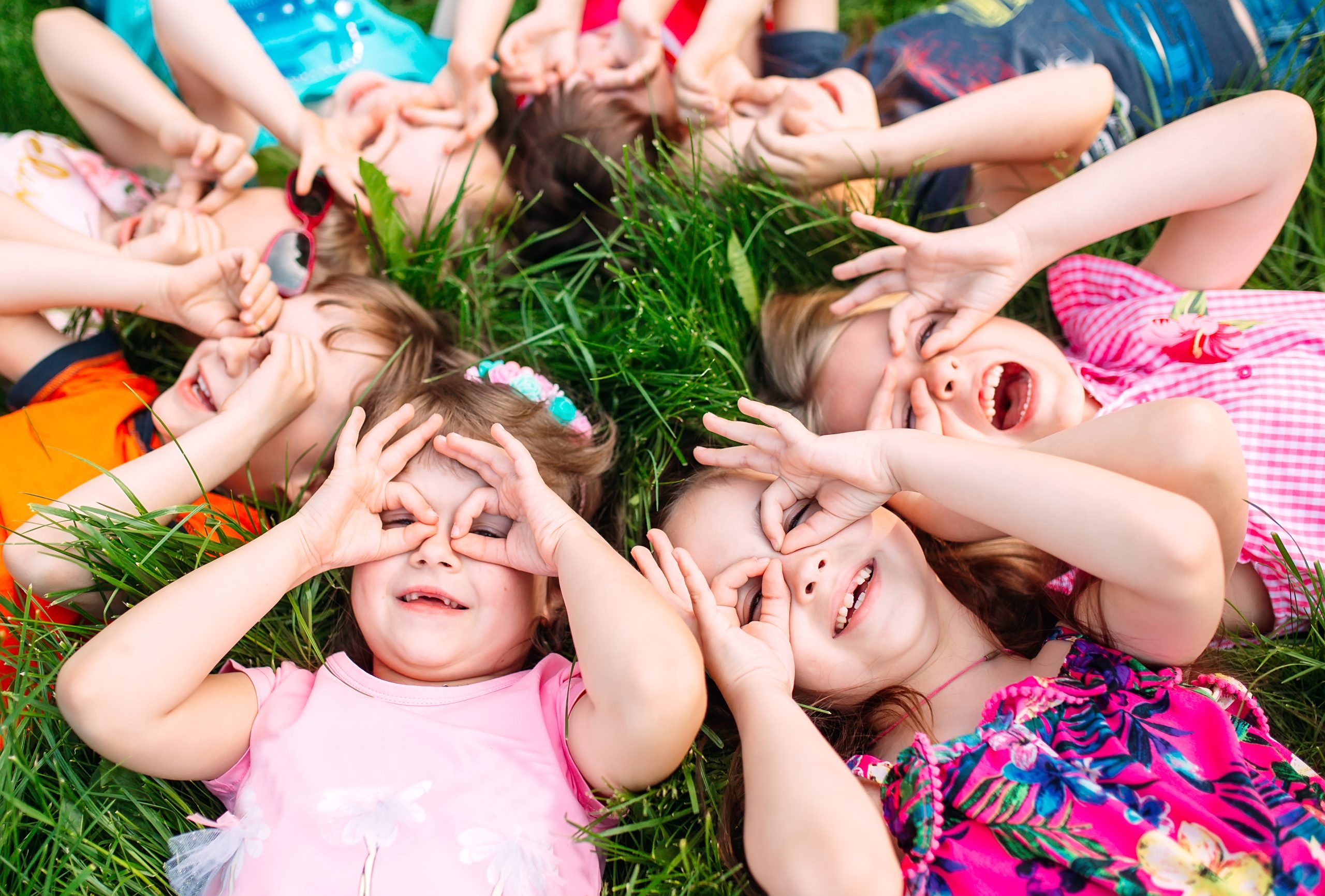 A group of children lying on the green grass in the Park.
